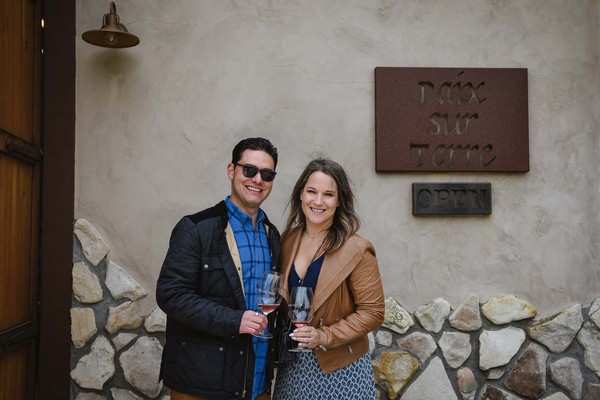 A couple poses in front of the tasting room