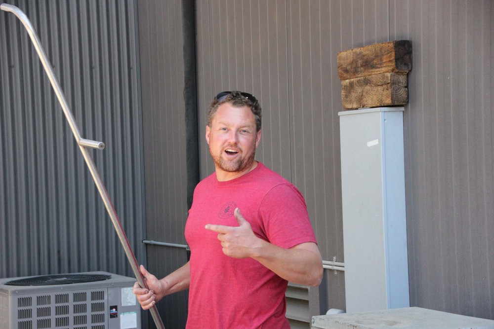 Ryan in the winery carrying a punchdown tool